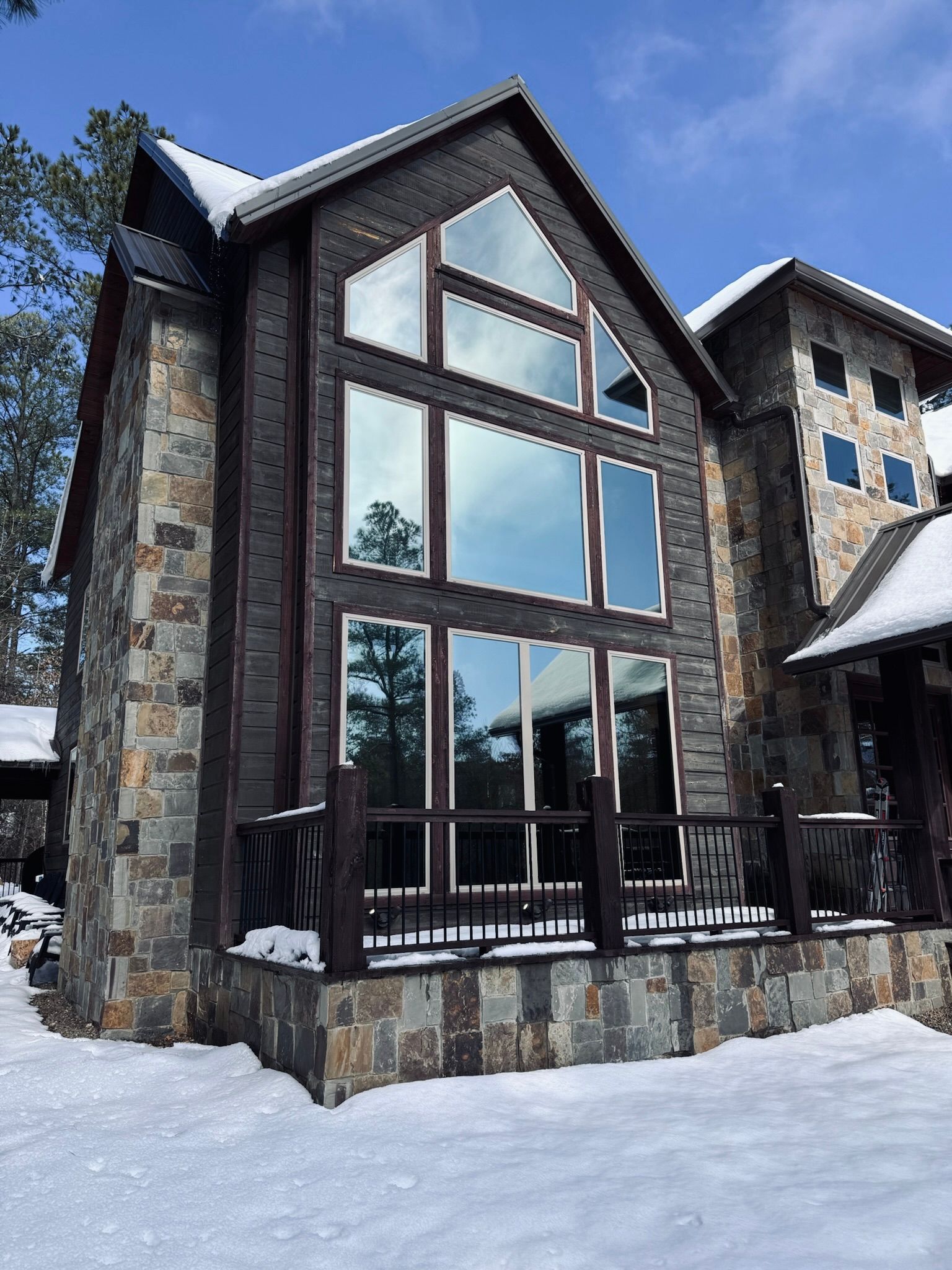 A large house with a lot of windows is covered in snow