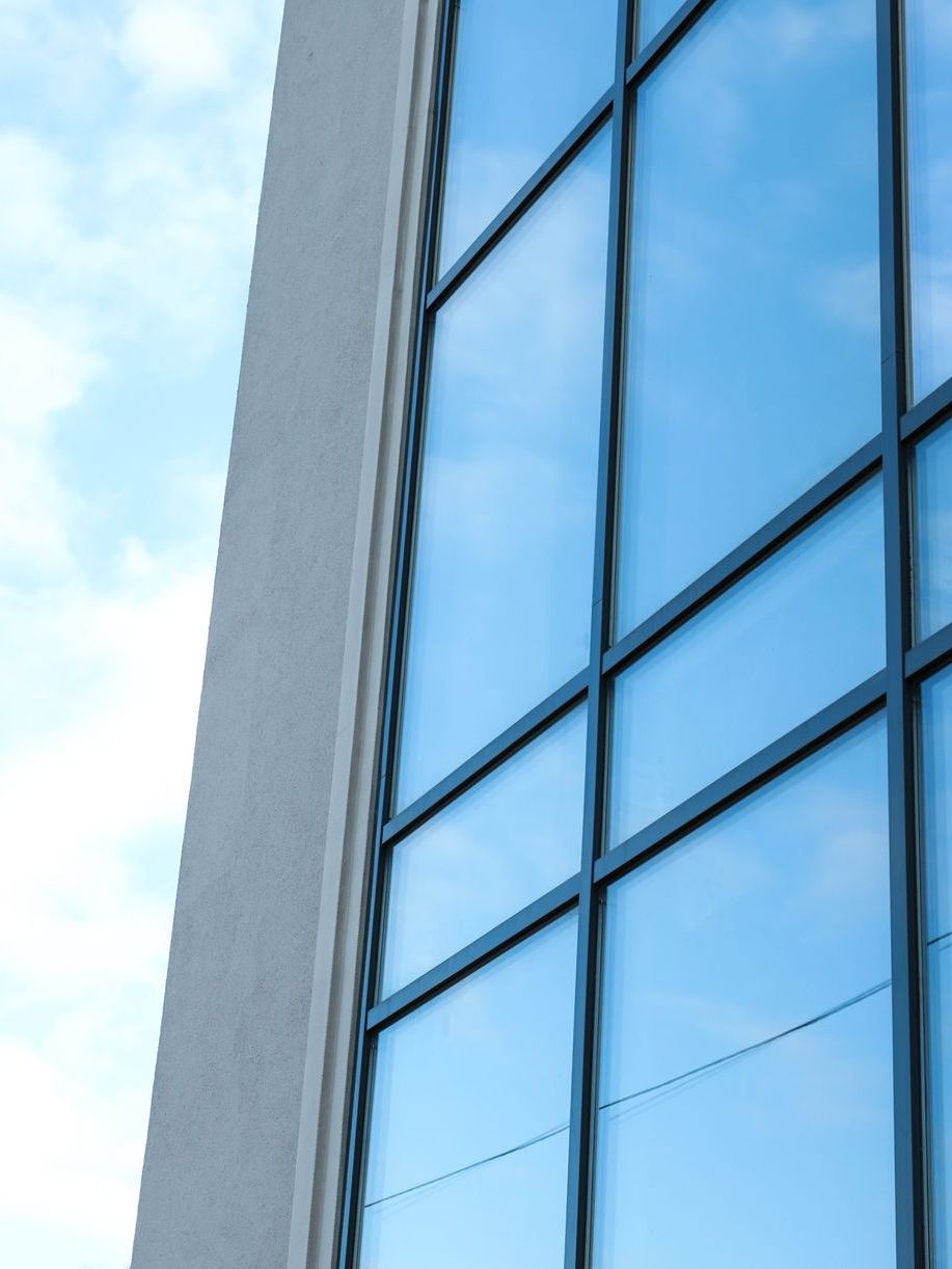 A building with a blue sky reflected in the windows