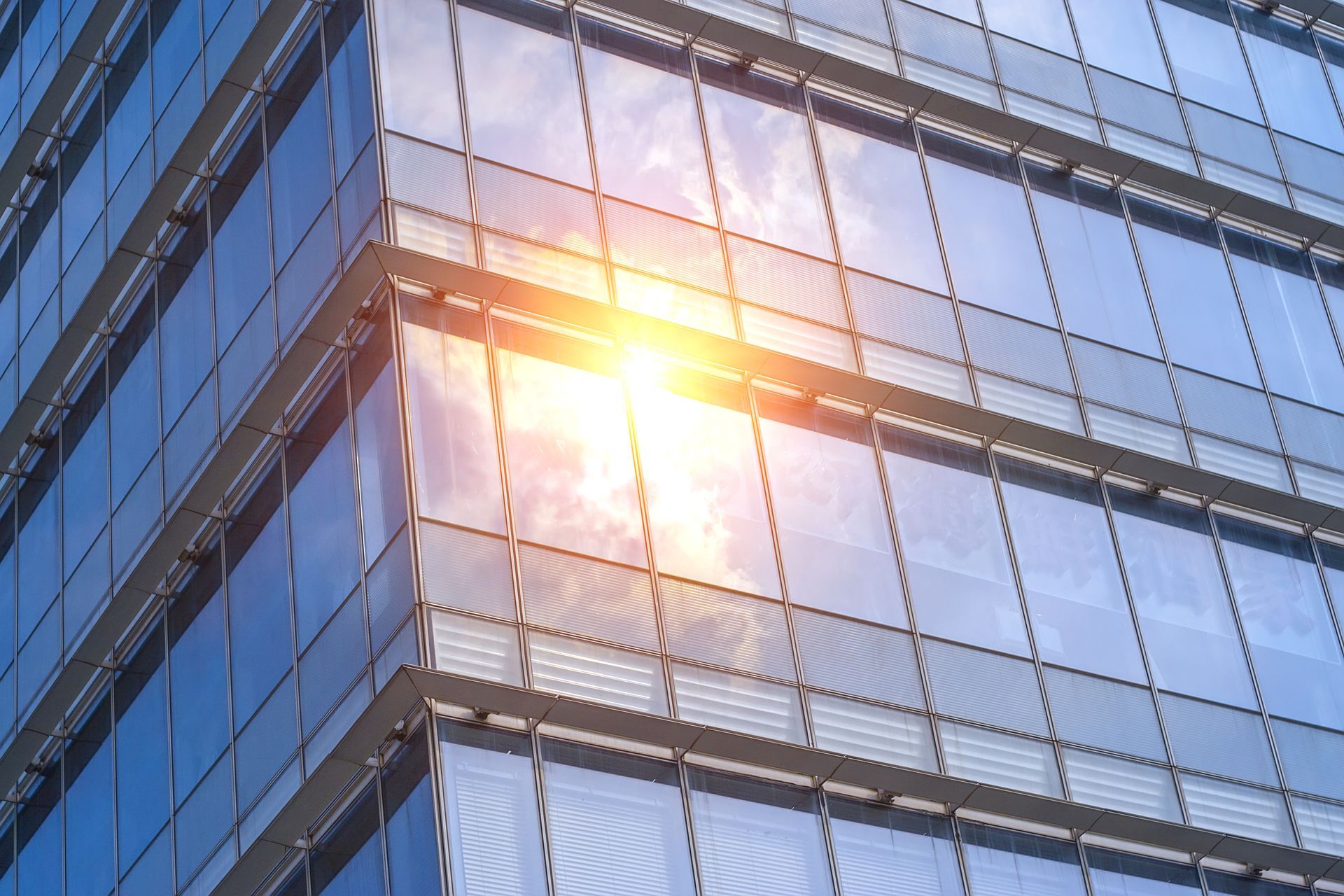 The sun is reflected in the windows of a tall building
