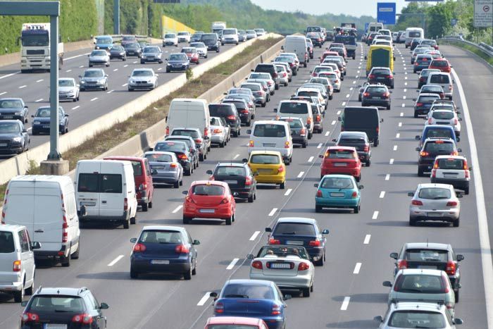 Heavy traffic jam on a multi-lane highway with cars, vans, and trucks stretching into the distance
