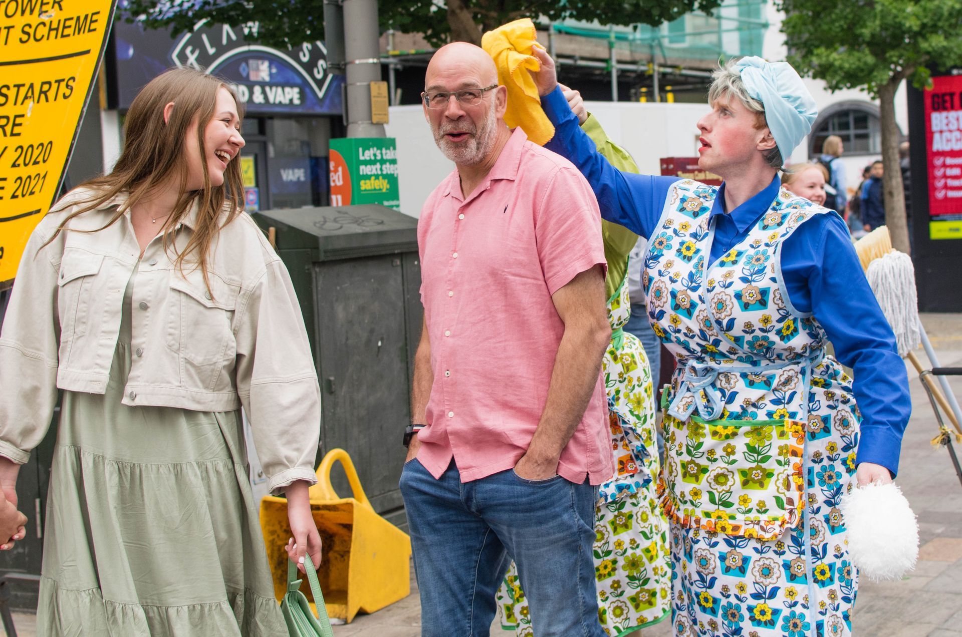 Dustbuster, Mildred, polishes the head of a bold man as his daughter laughs.