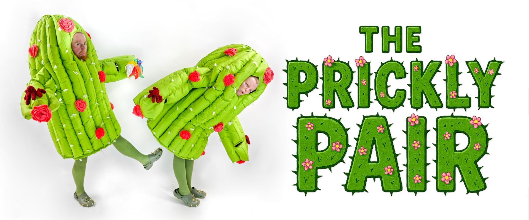 Two performers in oversized green cactus costumes with pink flowers pose playfully next to a bold illustrated logo reading “The Prickly Pair”.
