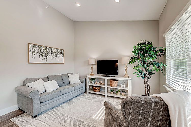 A living room with a couch , chair , and television.