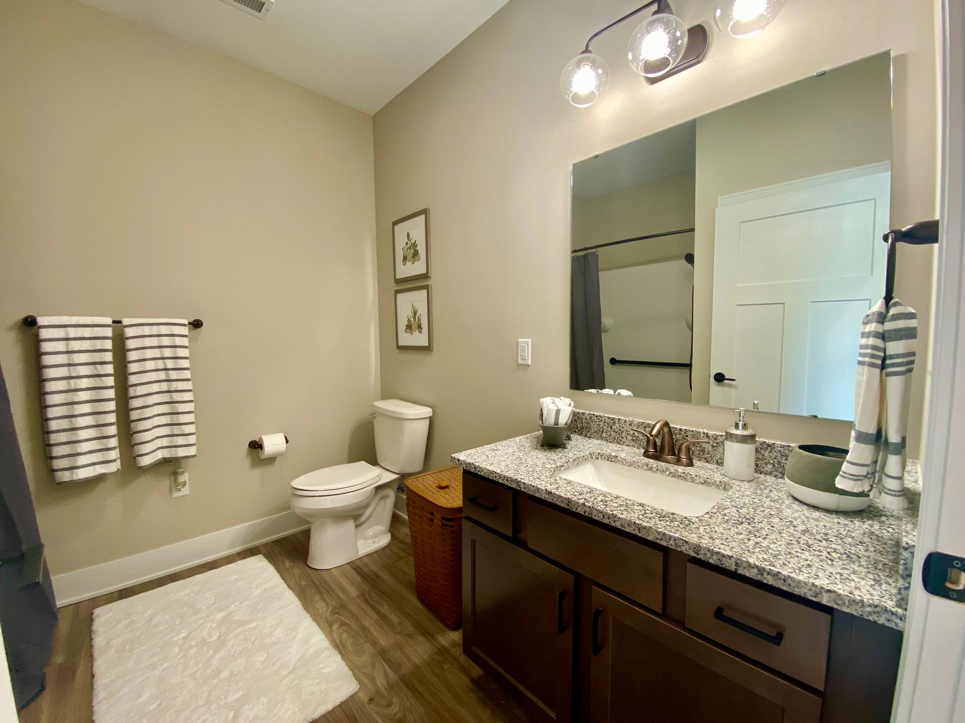 A bathroom with a toilet , sink , and mirror.