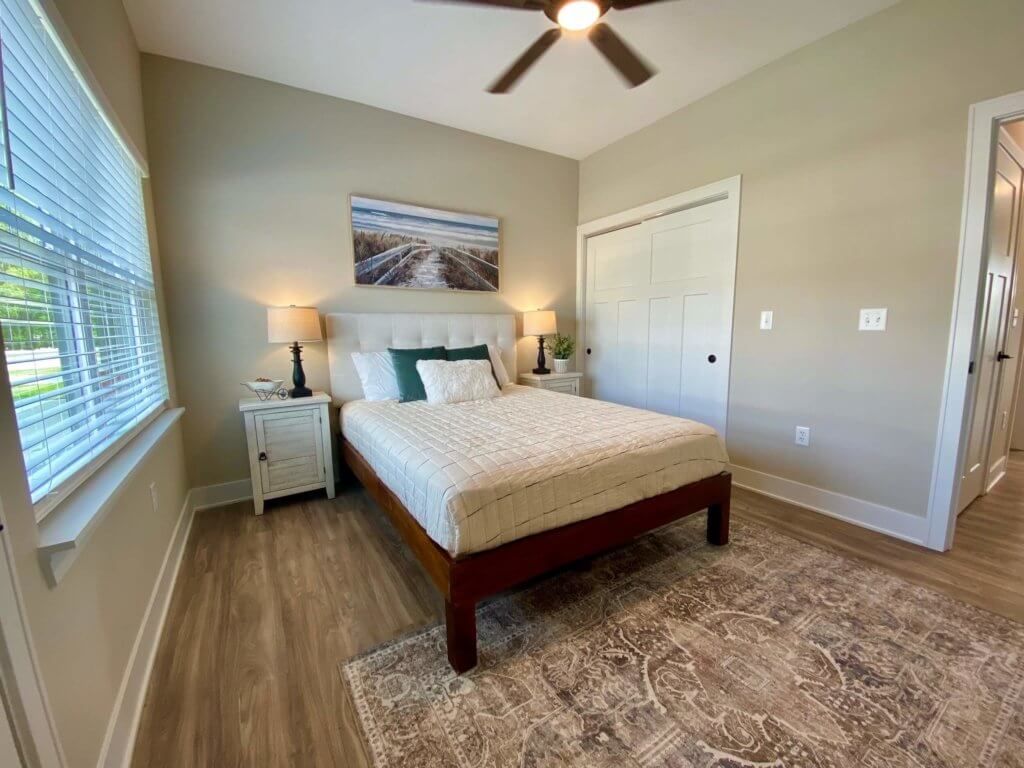 A bedroom with a bed , nightstand , and ceiling fan.