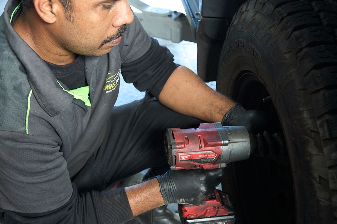 A man is working on a tire with a wrench.