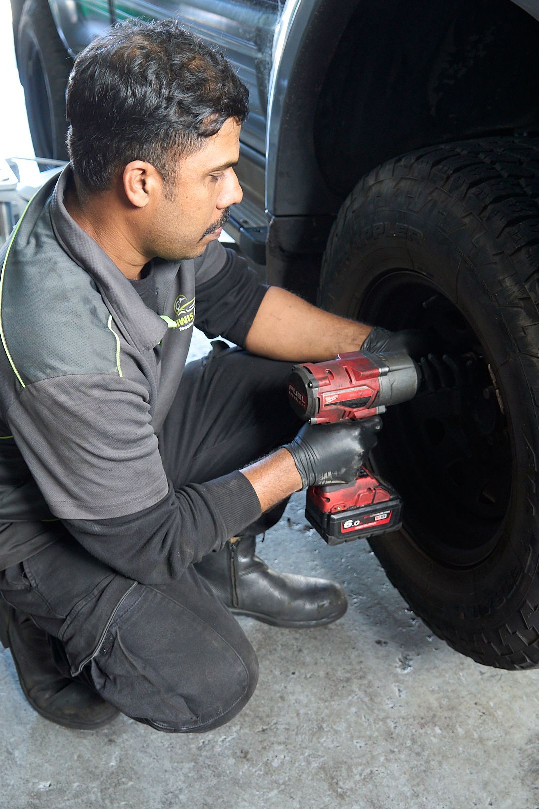A man is working on a tire with a wrench.