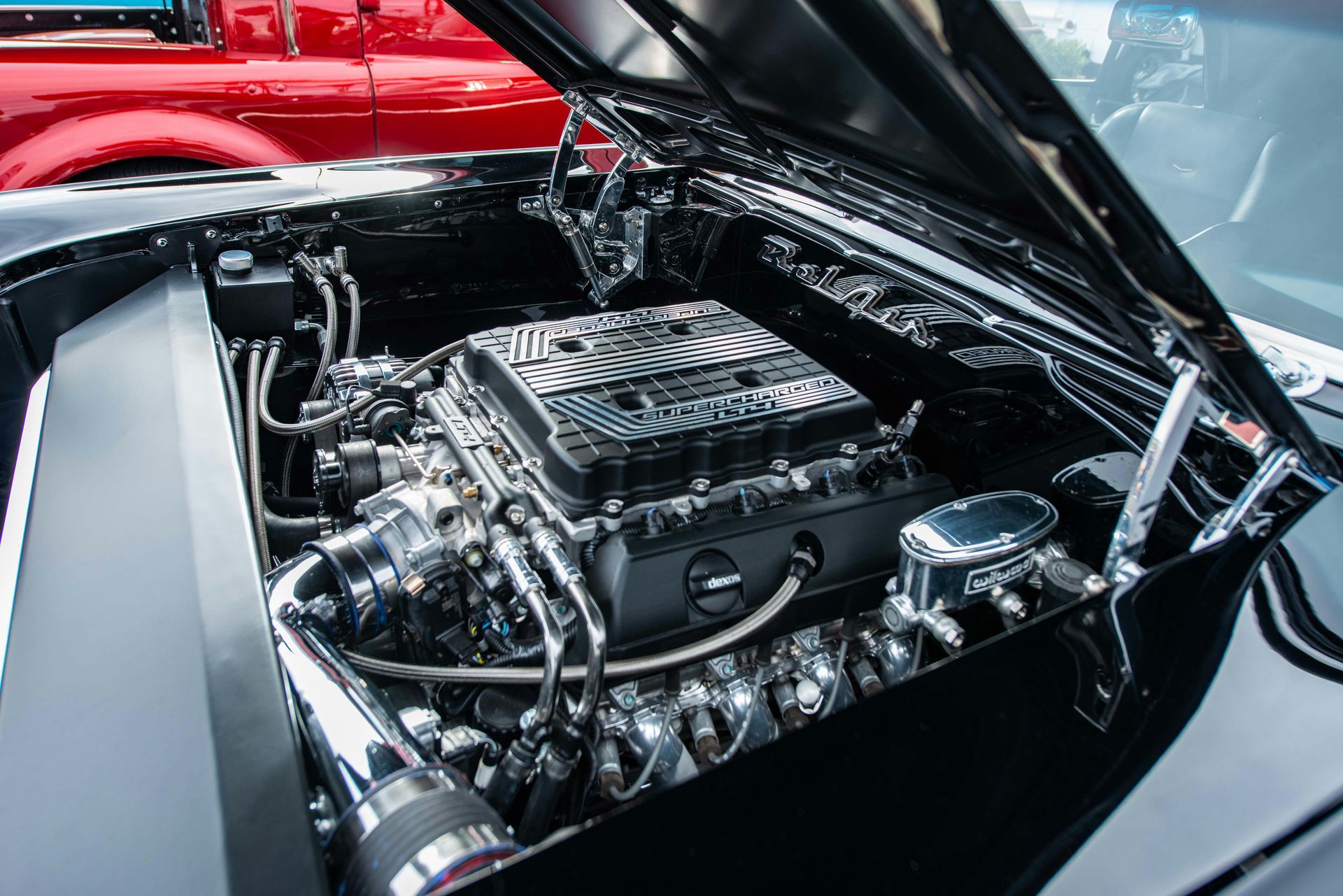A close up of a car engine with the hood open.