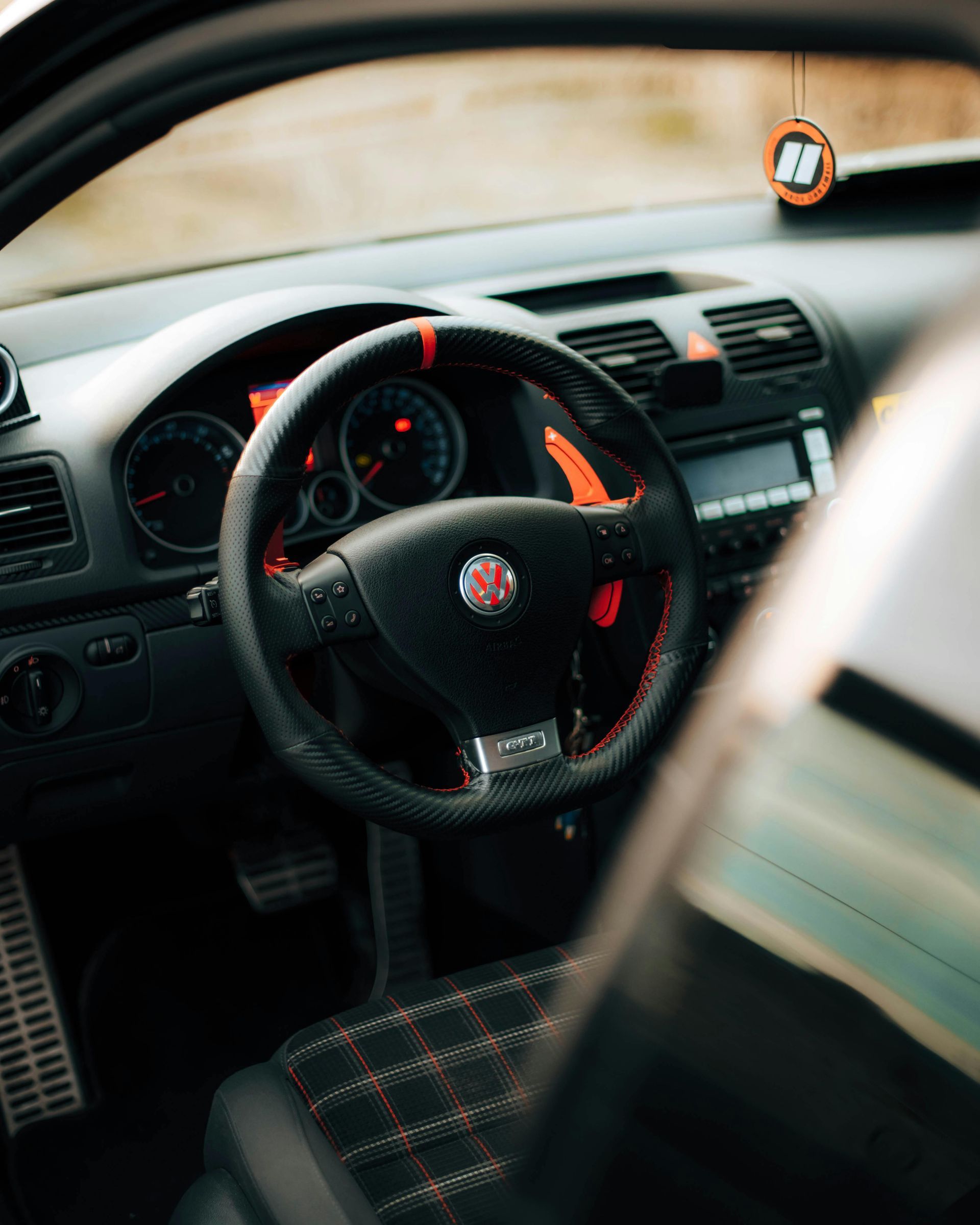 The inside of a car with a steering wheel and dashboard.