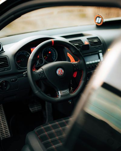 The inside of a car with a steering wheel and dashboard.