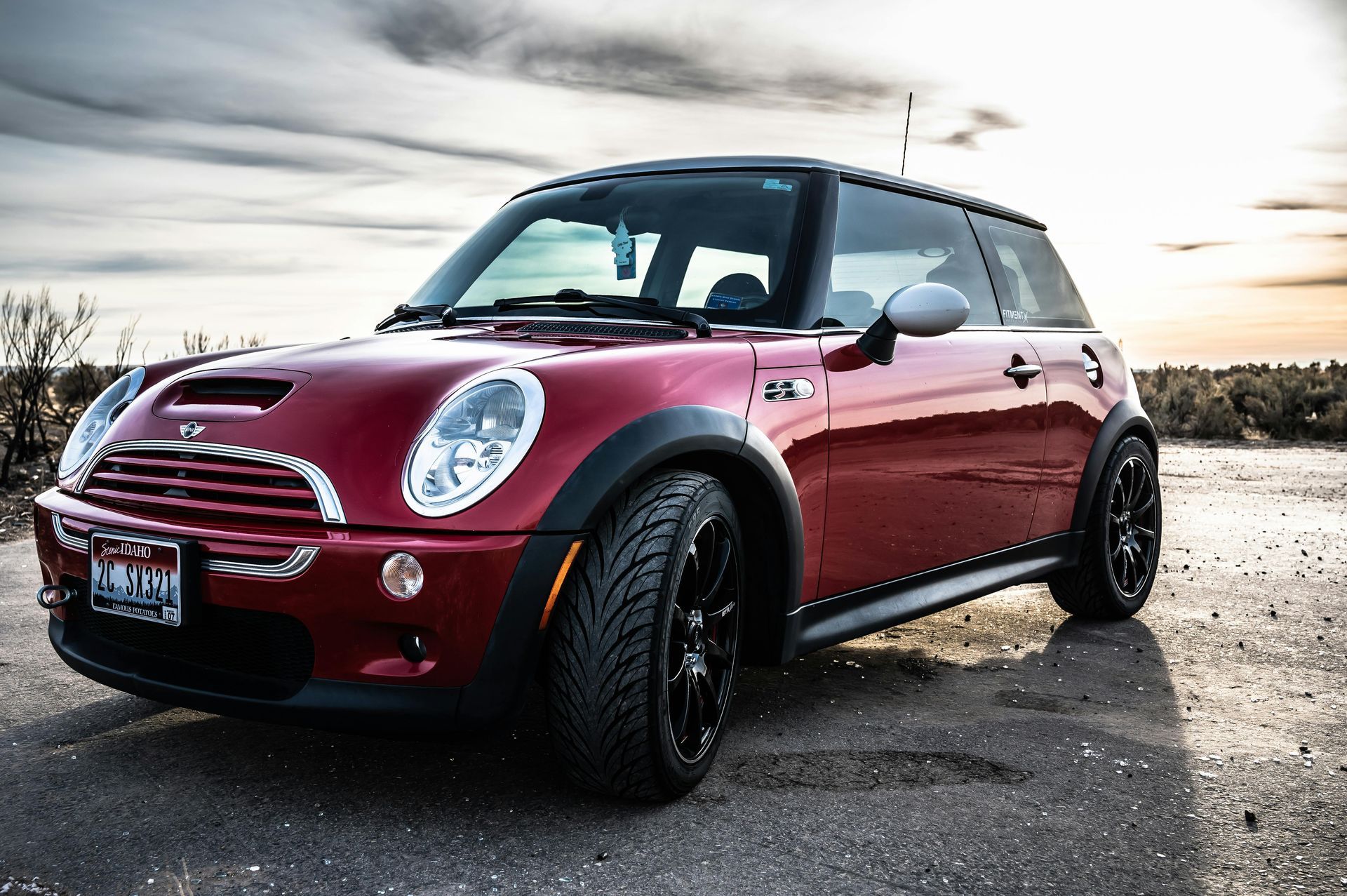 A red mini cooper is parked on the side of the road