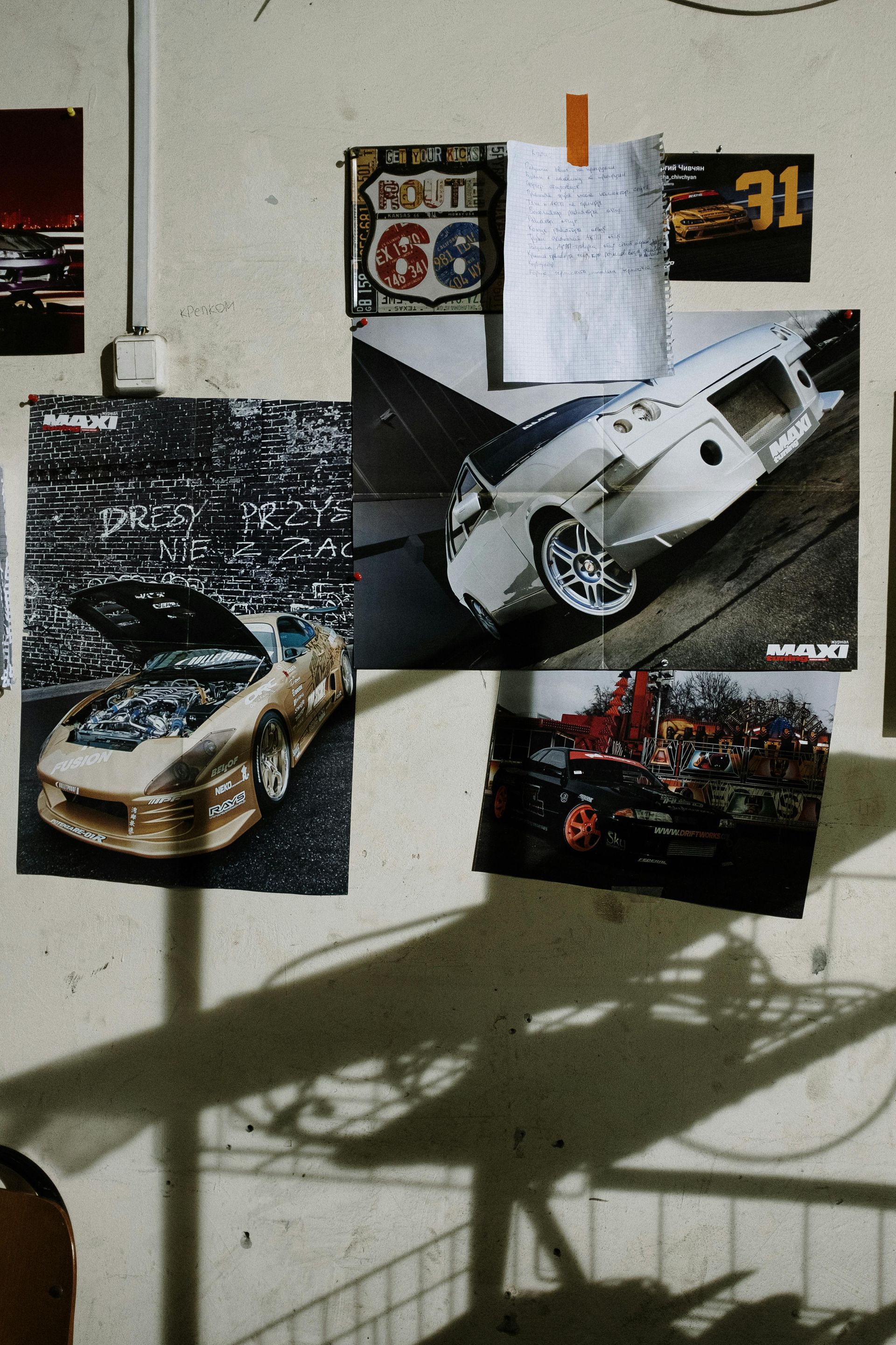 A wall with pictures of cars and a sign that says 66