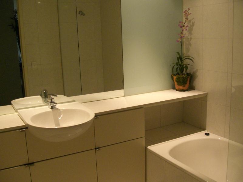 A bathroom with a sink , tub and mirror