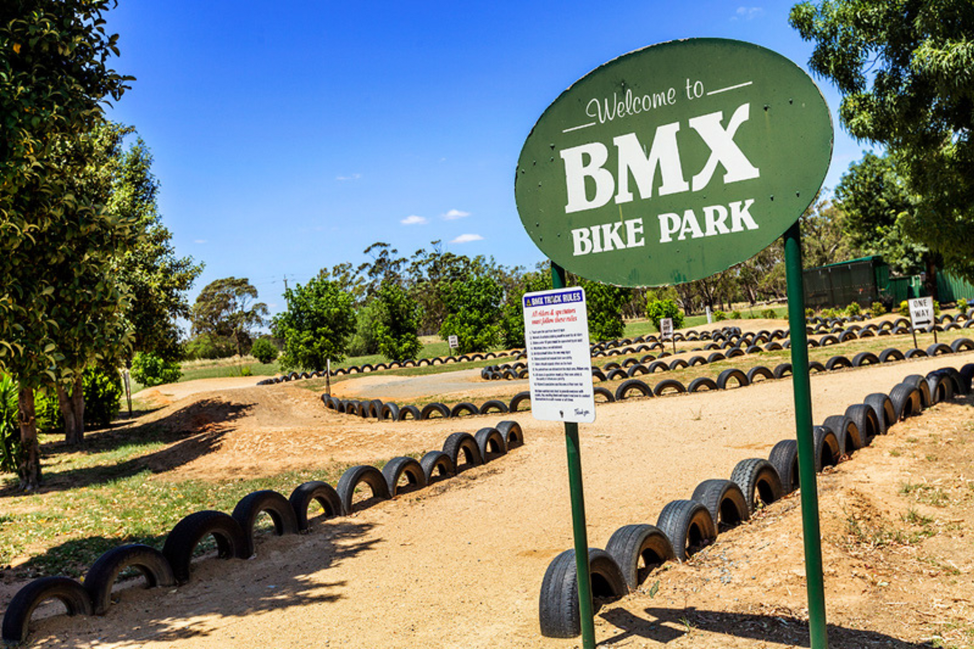 A green sign that says bmx bike park on it
