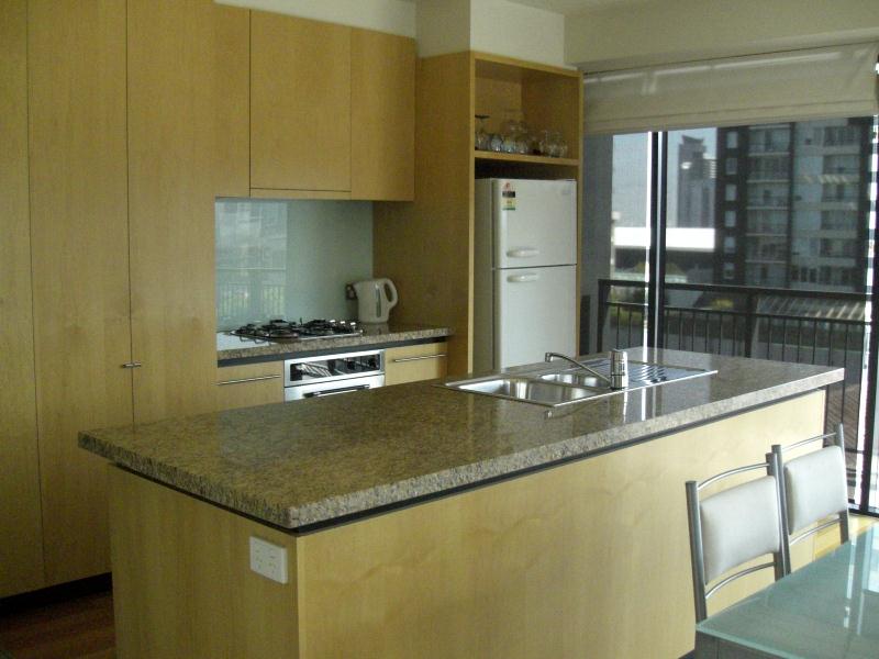 A kitchen with a large island and a refrigerator