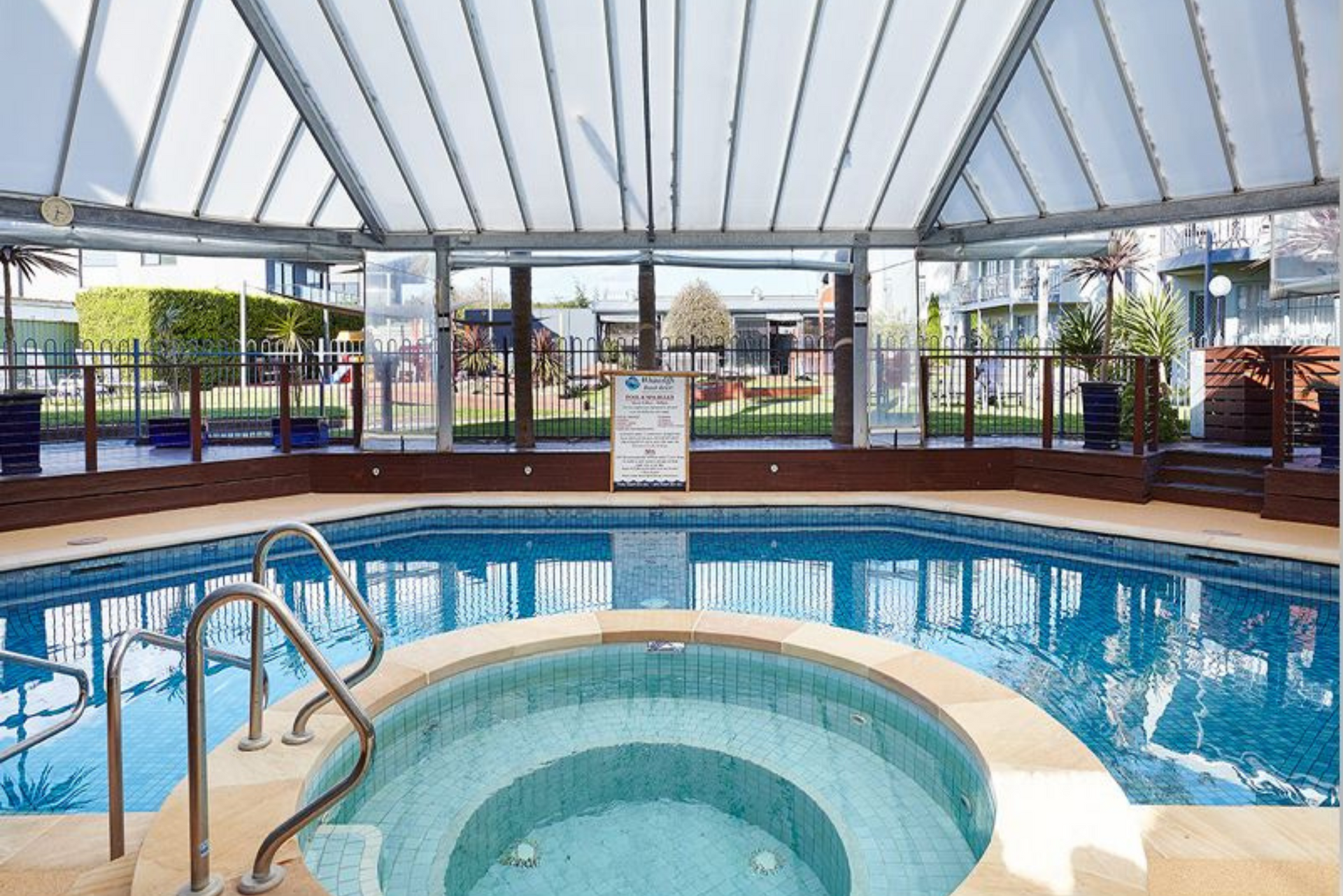 A large indoor swimming pool with a hot tub in the middle