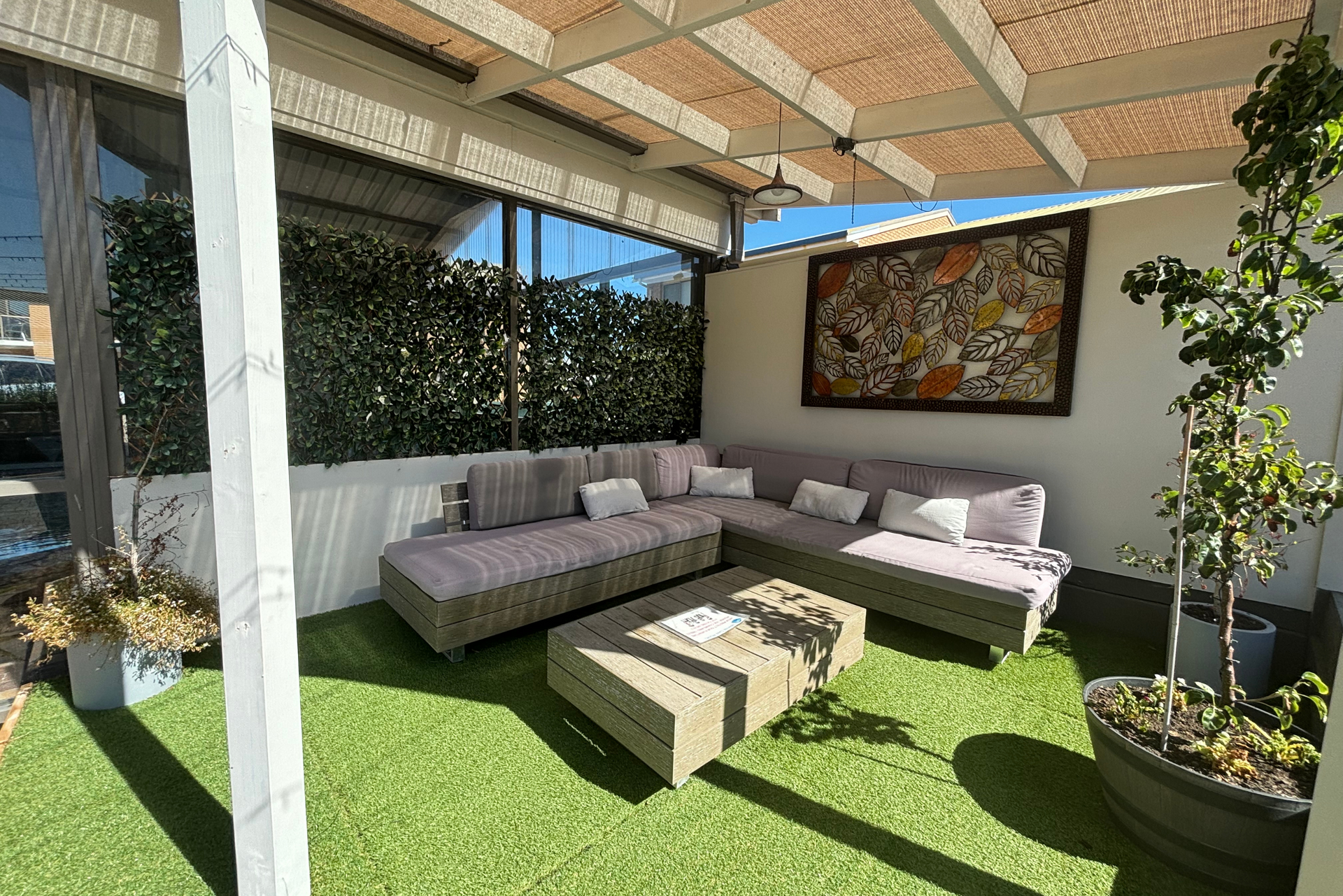 A patio with a couch and a table under a pergola.