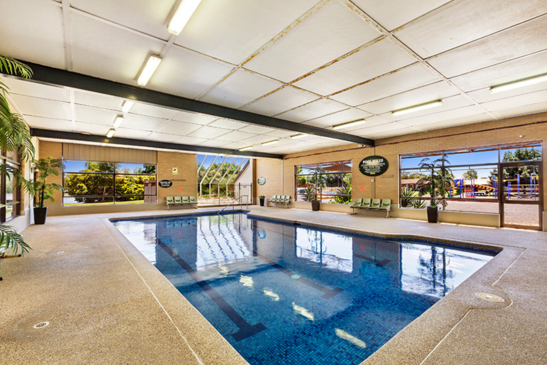 A large indoor swimming pool with a lot of windows