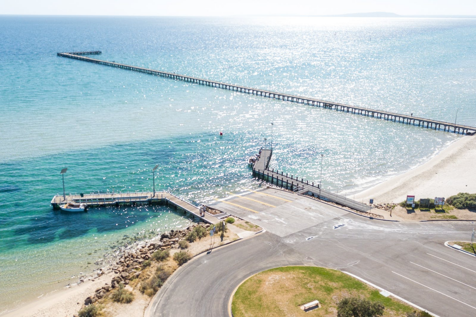 An aerial view of a pier leading into the ocean.