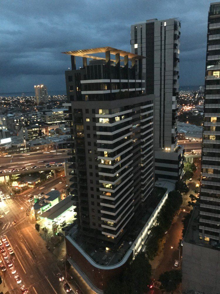 A view of a city at night with a tall building in the foreground