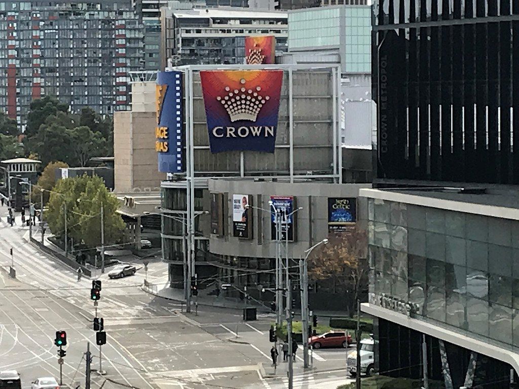 An aerial view of a city street with a crown sign on the side of a building.