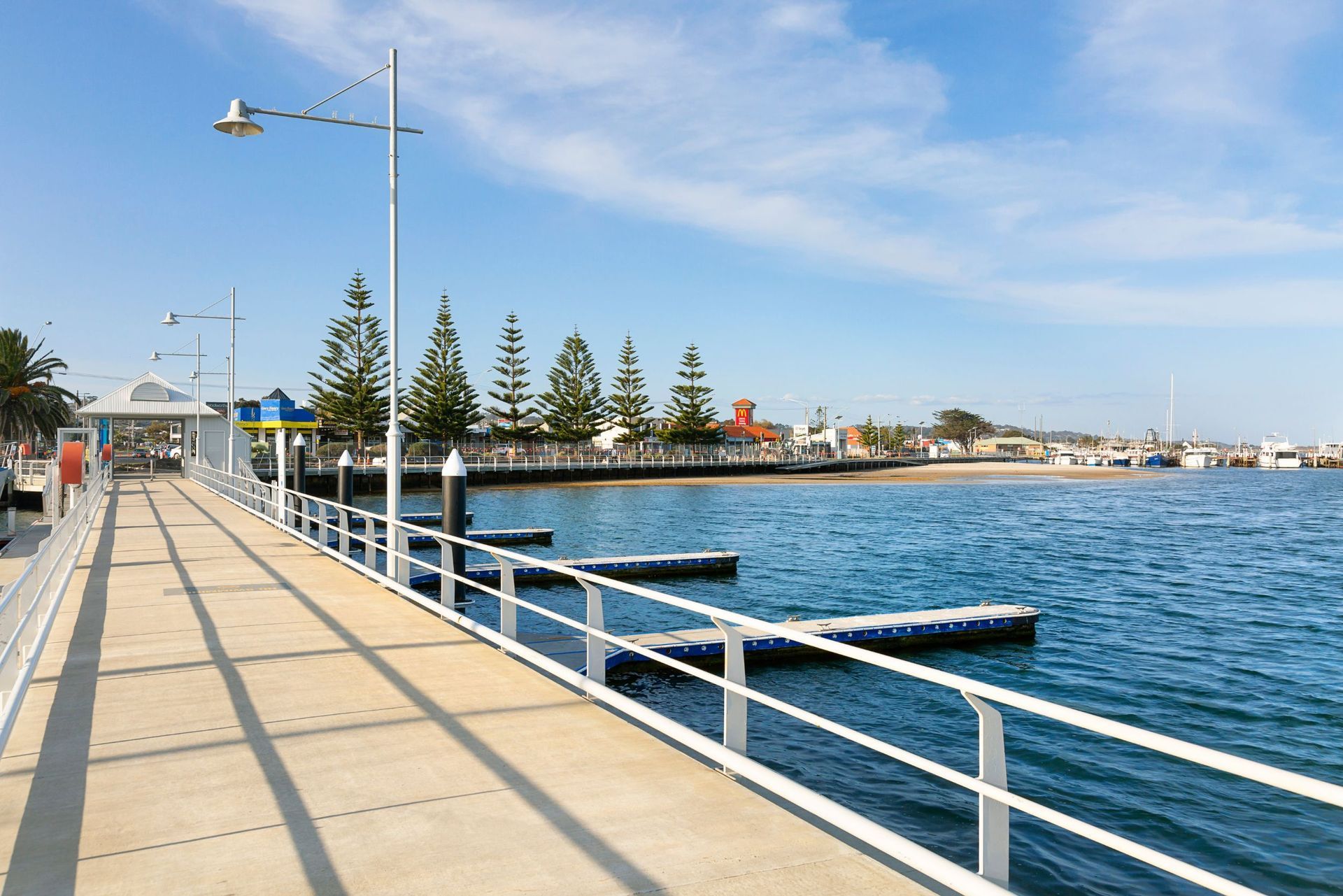 A pier with a white railing overlooking a body of water.