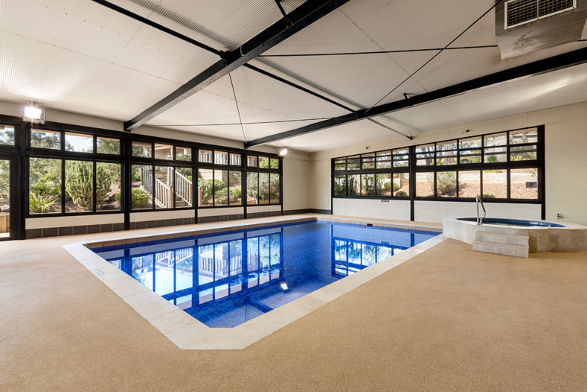 A large indoor swimming pool with lots of windows