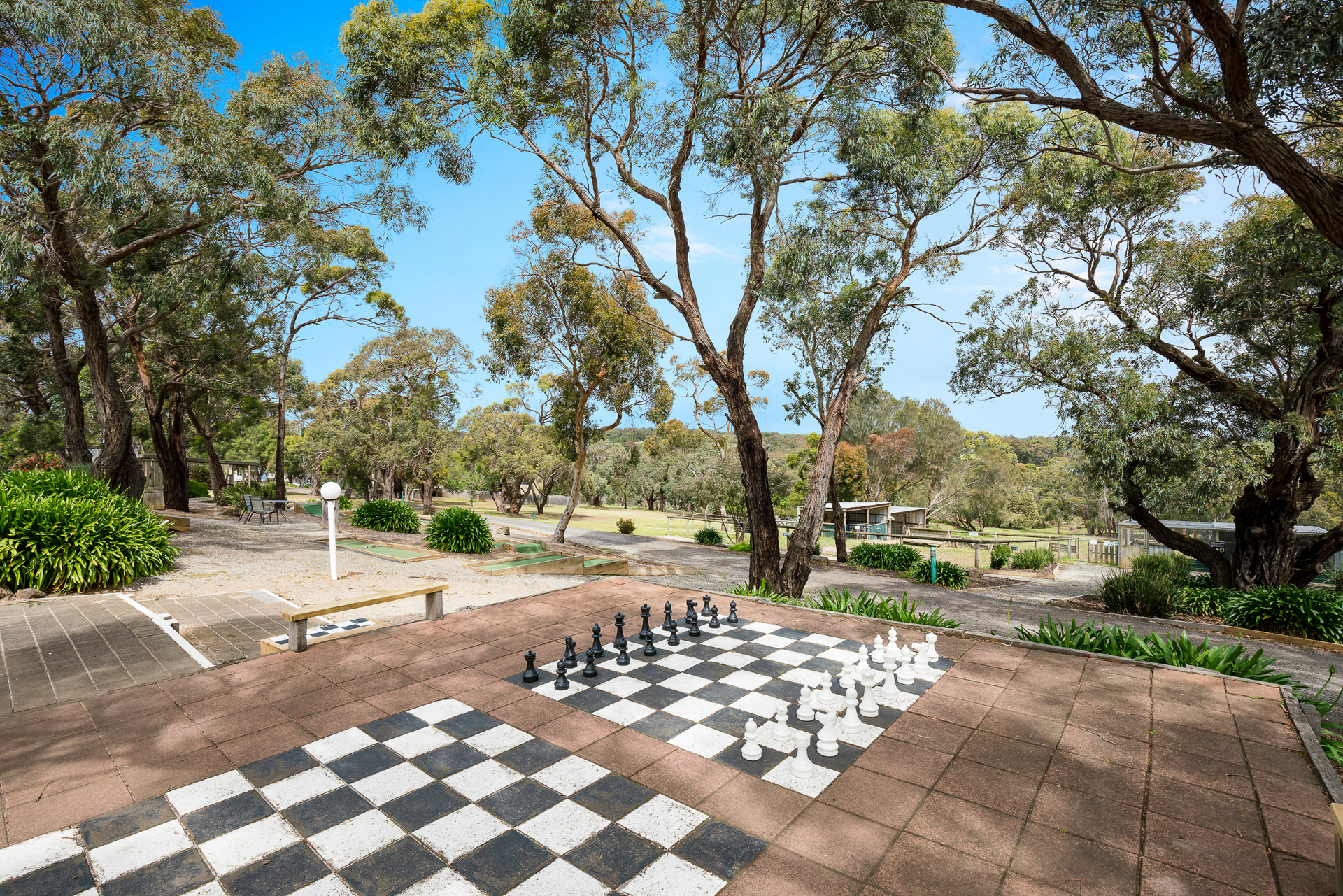 There is a large chess board in the middle of a park.