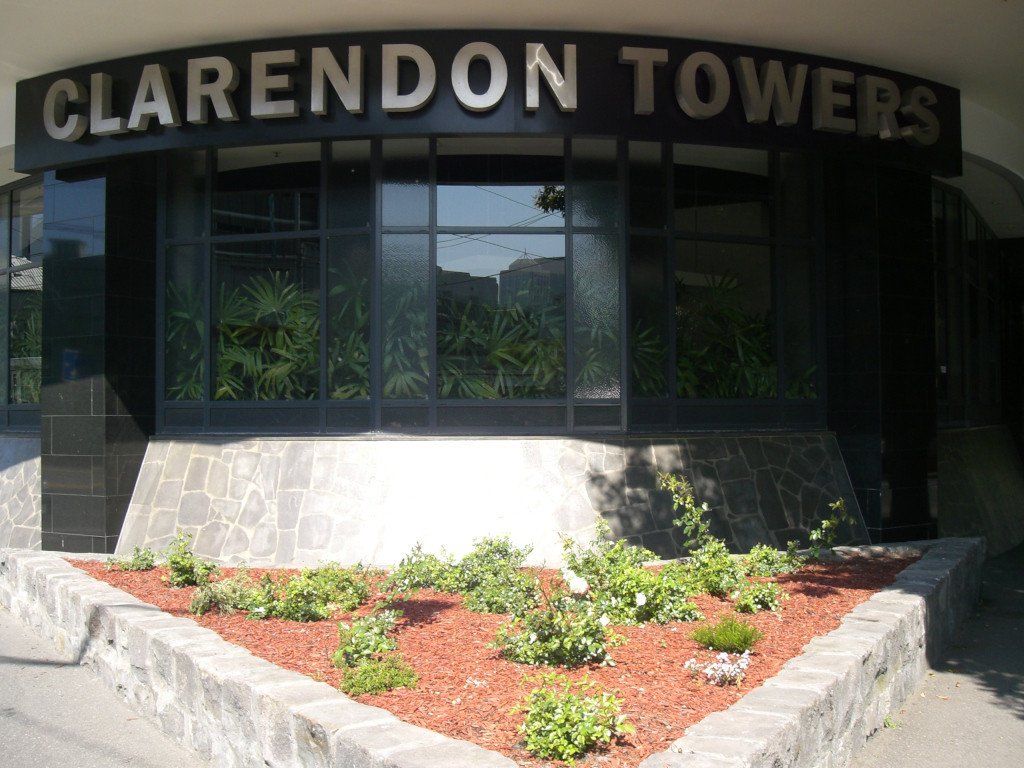 The clarendon towers building has a planter in front of it