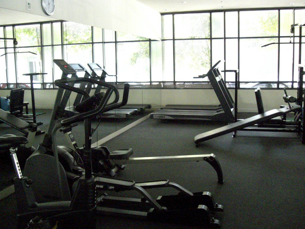 A gym with a lot of equipment and a clock on the wall