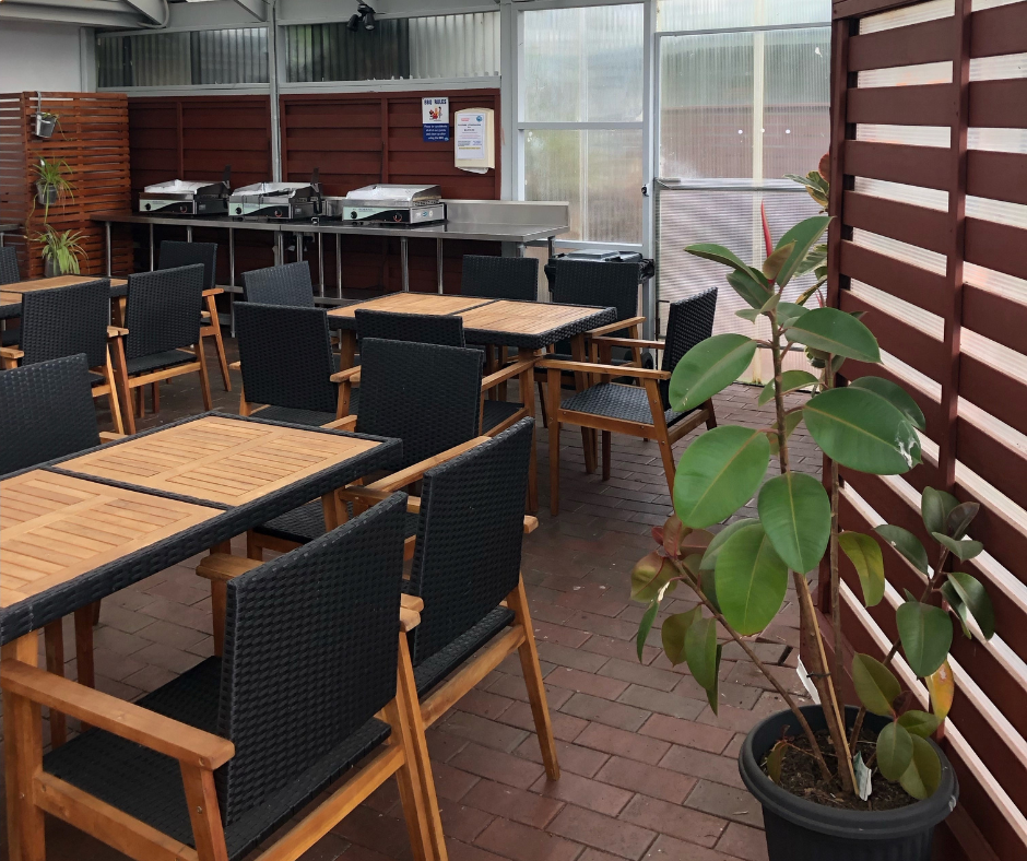A restaurant with tables and chairs and a potted plant
