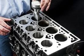 Tren de aterrizaje de un vehículo, visto desde abajo, que muestra la suspensión, las ruedas y los paneles protectores, todo en tonos negro y plateado.