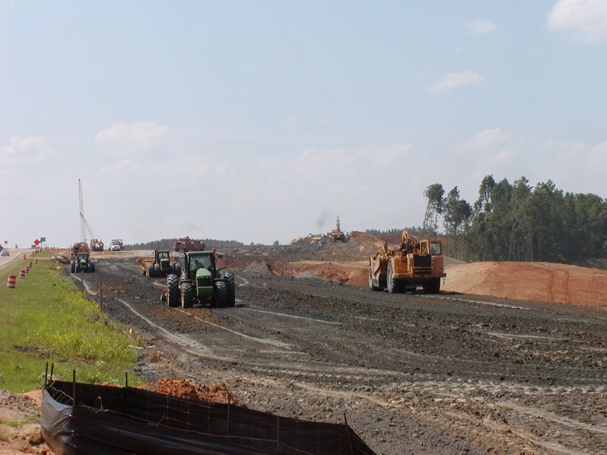 Tractors and bulldozers are working on a dirt road