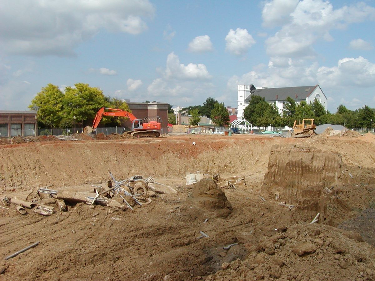 A construction site with a house in the background