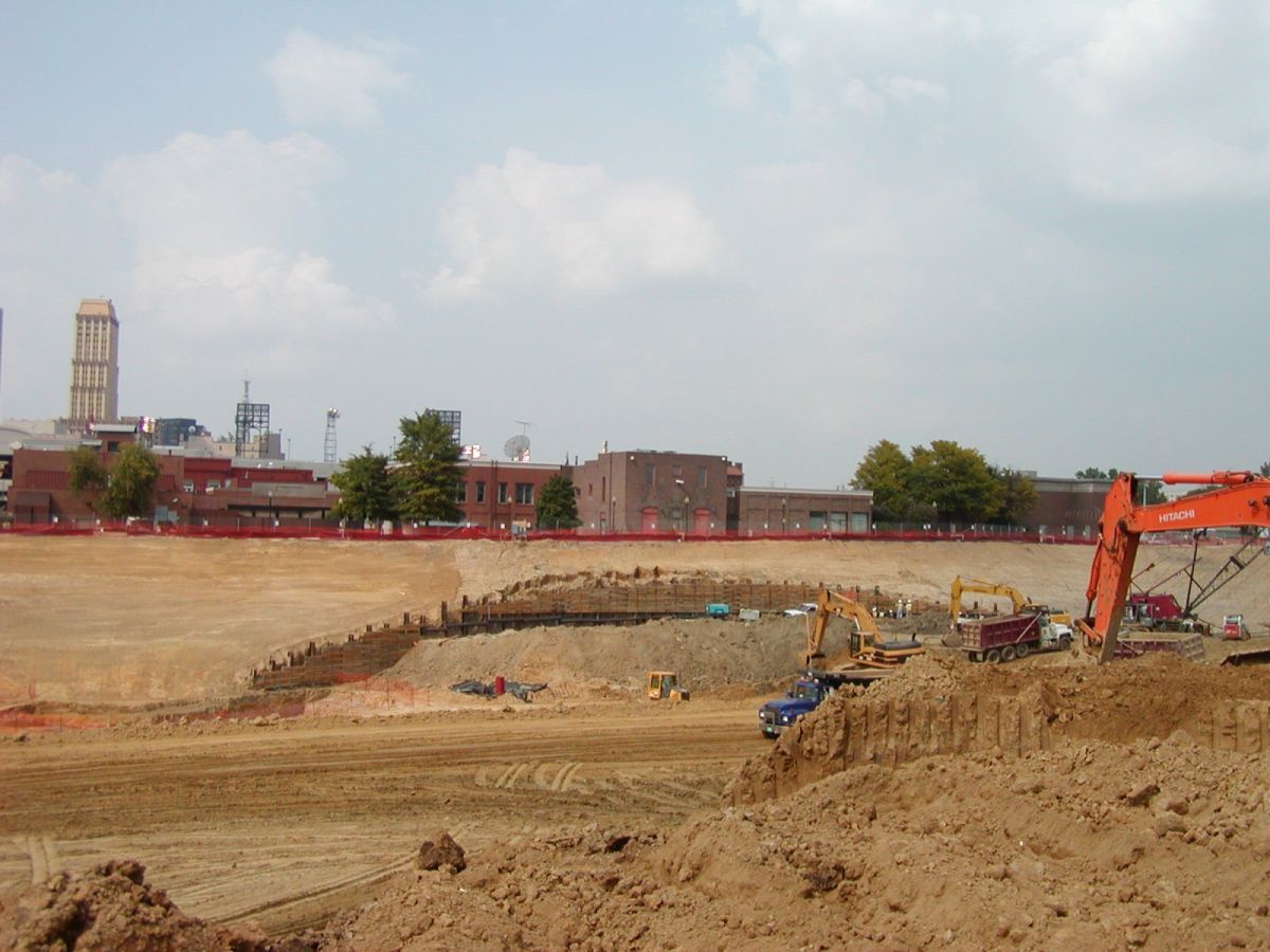 A construction site with a large orange excavator in the foreground