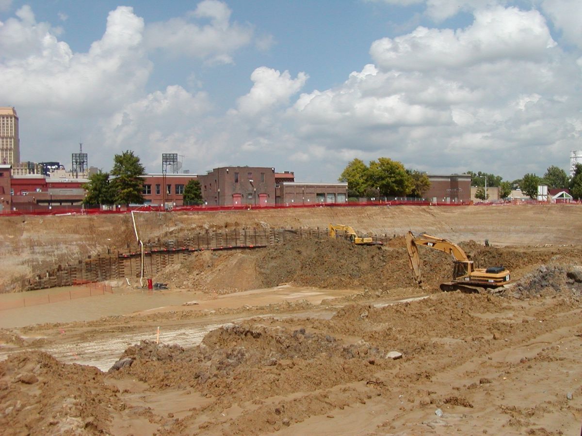 A construction site with a lot of dirt and buildings in the background