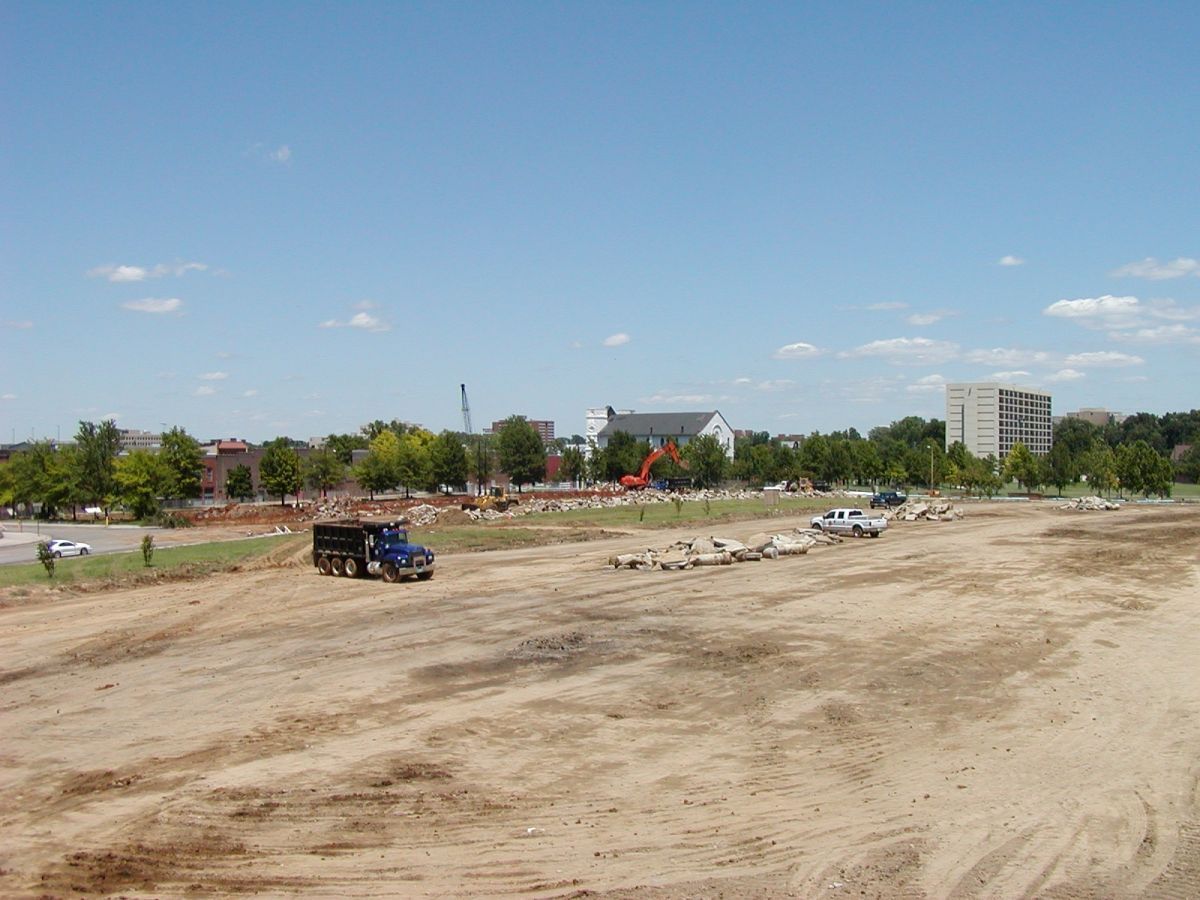 A truck is parked in the middle of a dirt field.