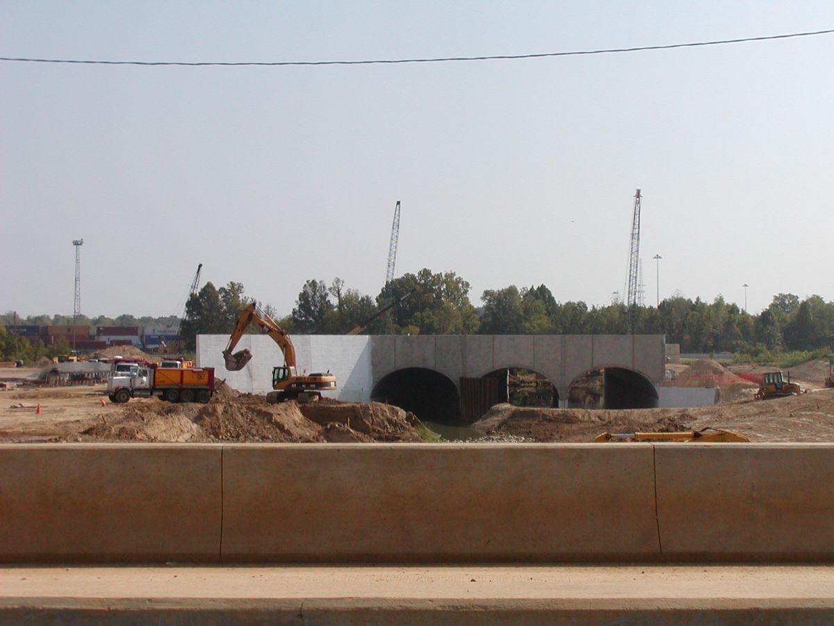 A construction site with a yellow excavator in the foreground