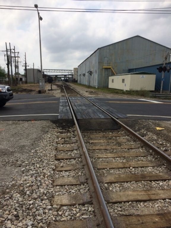 A railroad crossing with a building in the background
