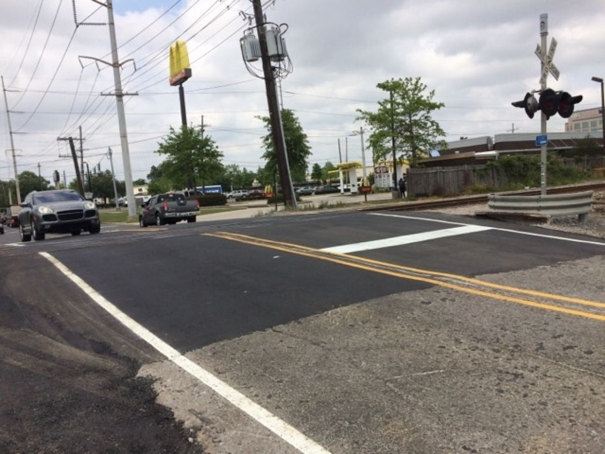 A train crossing with a mcdonald 's in the background