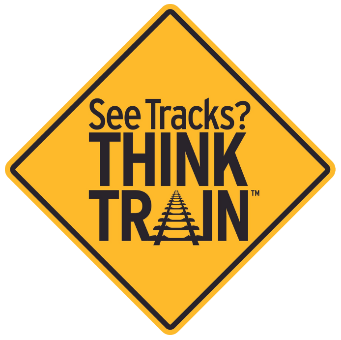 A yellow sign that says see tracks think train