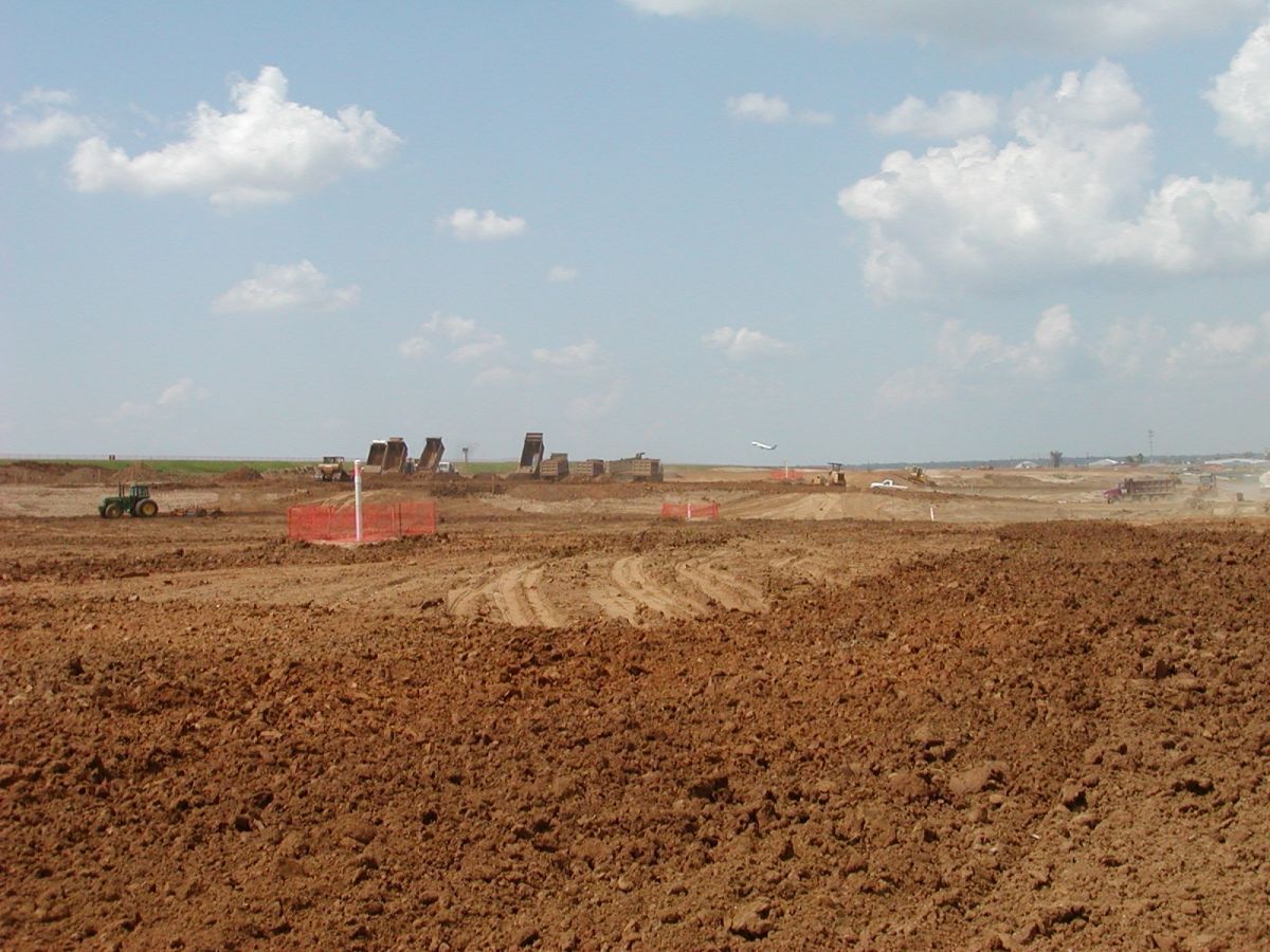 A large dirt field with a blue sky in the background