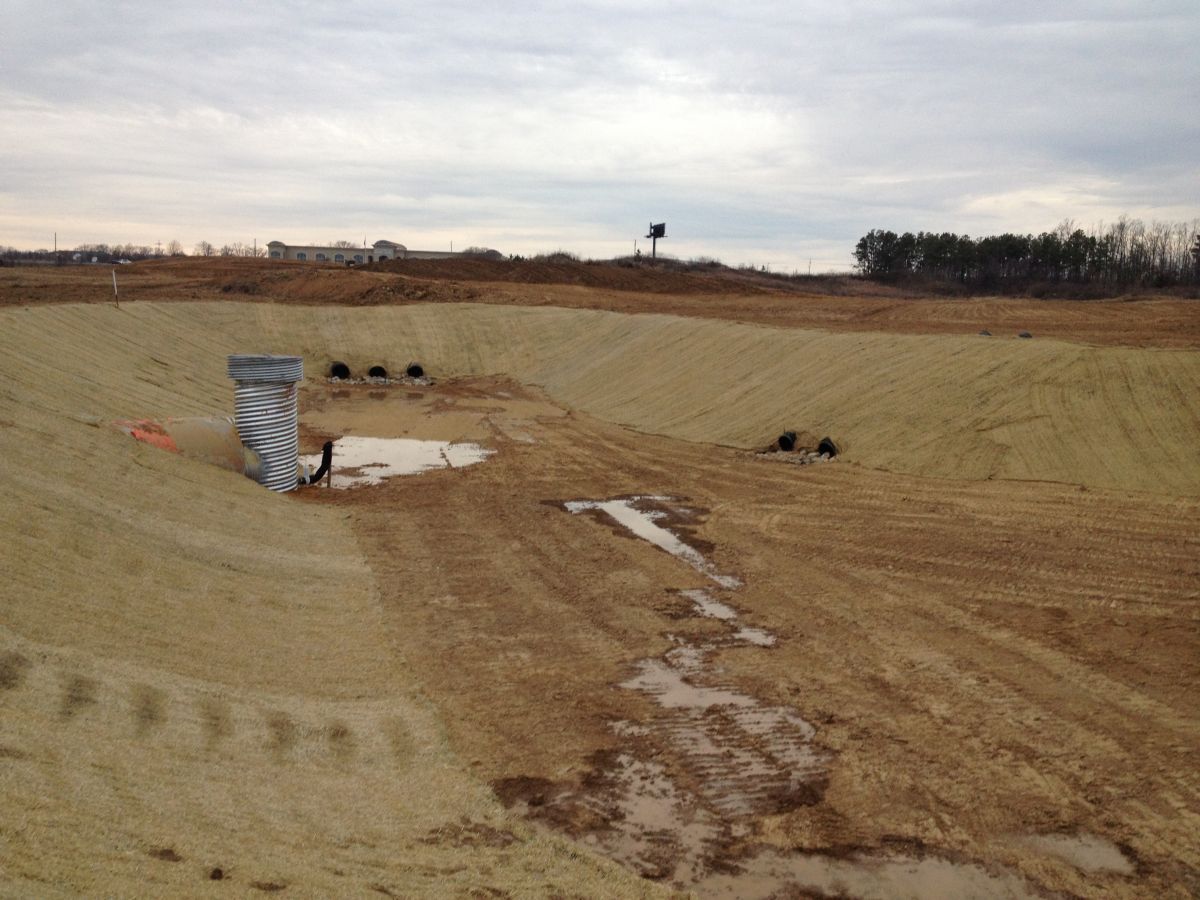 A large dirt field with a few trees in the background