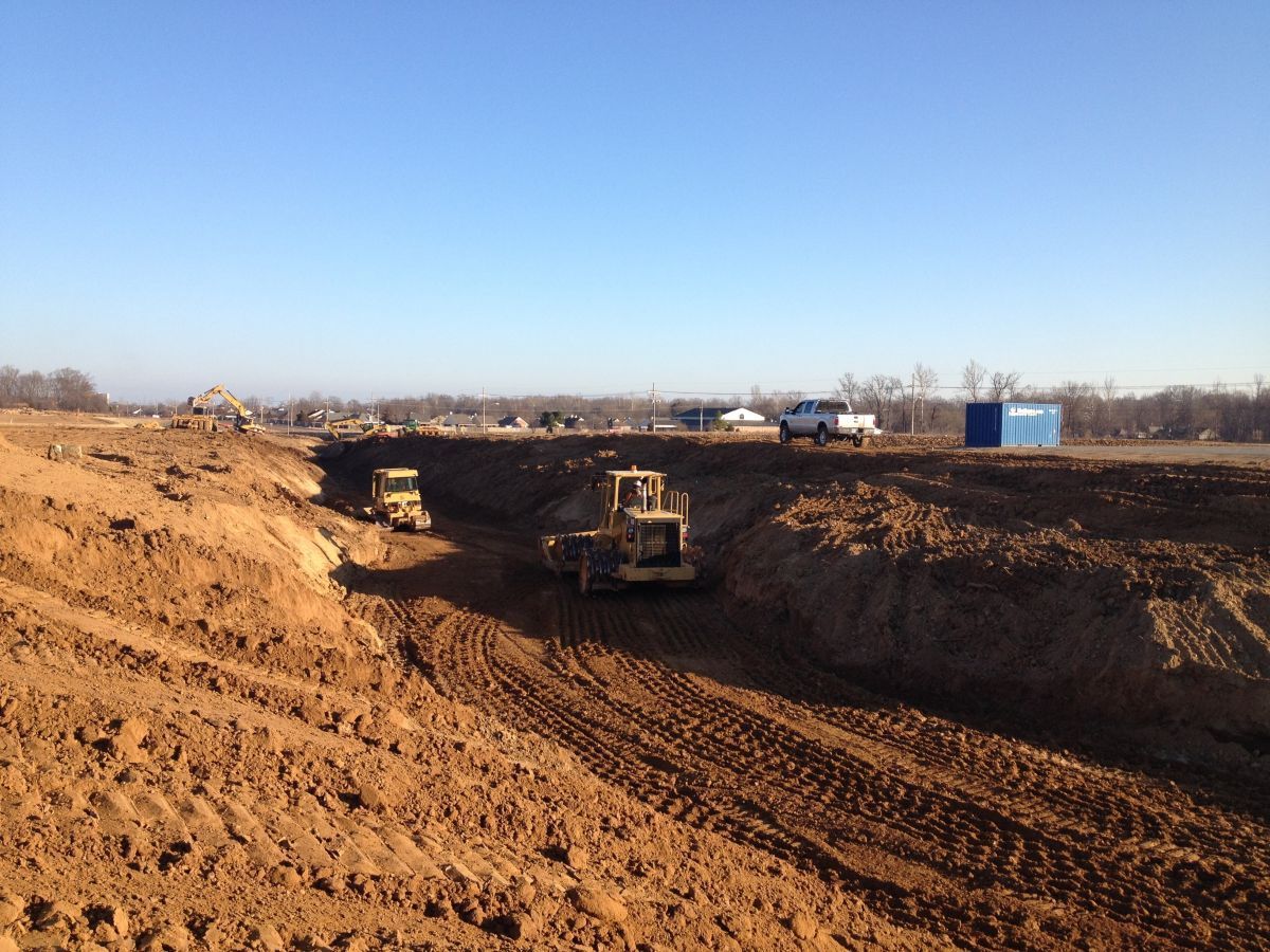 Two bulldozers are working on a dirt road