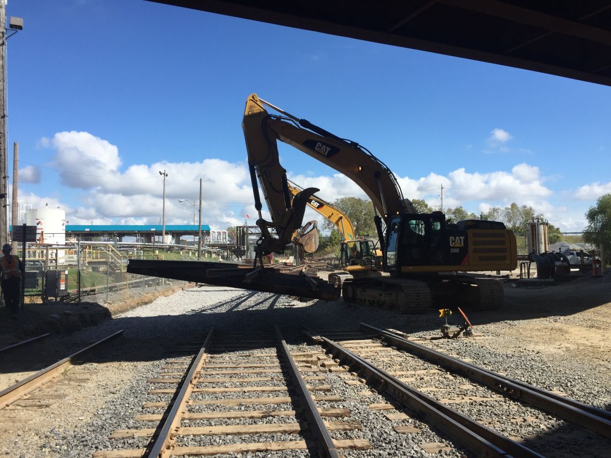 A large cat excavator is working on train tracks