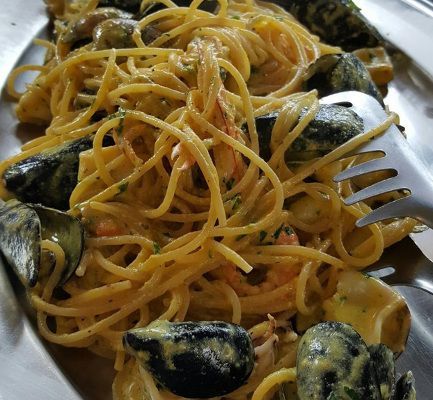 Spaghetti ai frutti di mare in salsa cremosa, guarnito con cozze