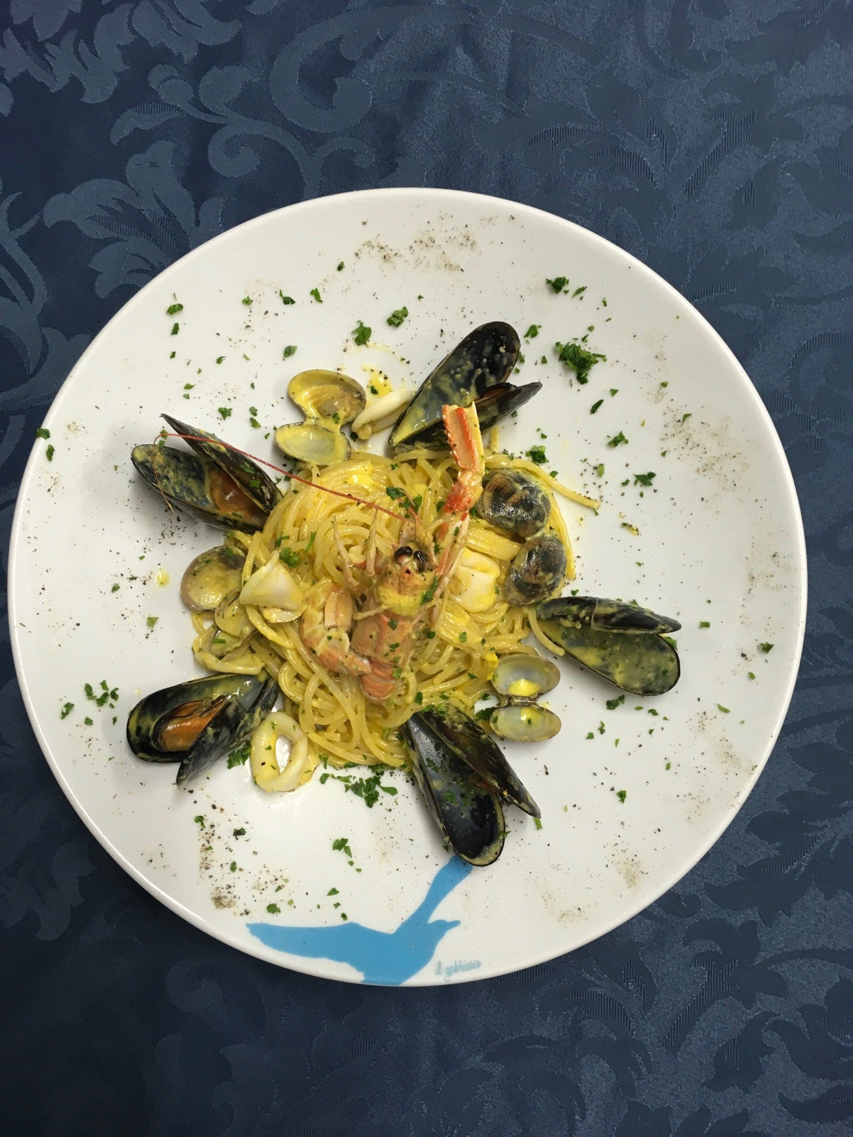 Piatto di pasta ai frutti di mare con cozze, vongole ed erbe aromatiche