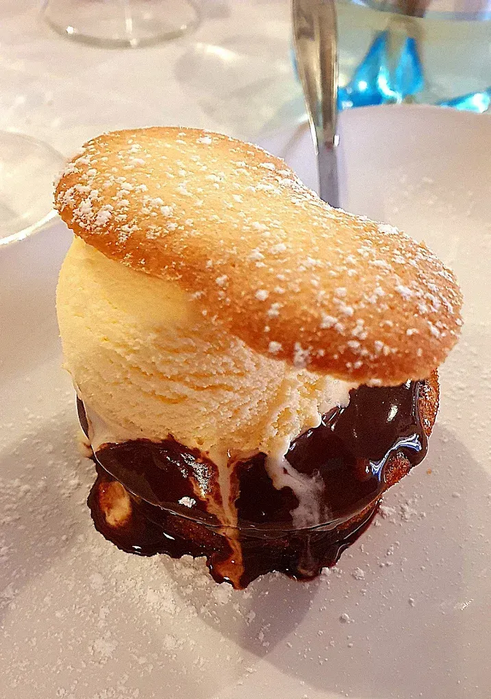 Sandwich di gelato: gelato alla vaniglia su cioccolato, con una superficie di biscotto e spolverato con zucchero a velo.