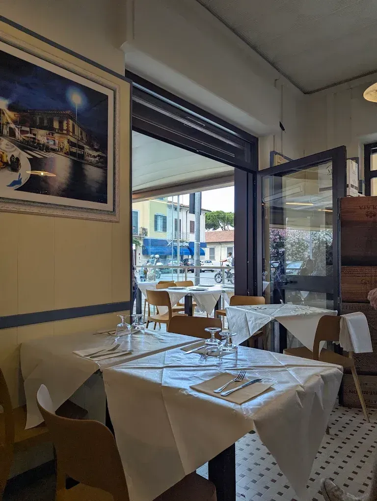 Interno di un ristorante con tovaglie bianche, tavoli apparecchiati 