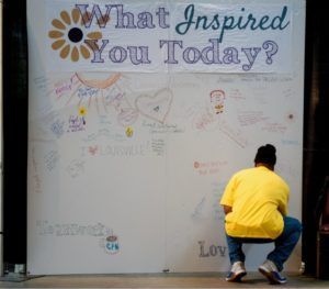 Person writing on a wall with the words 